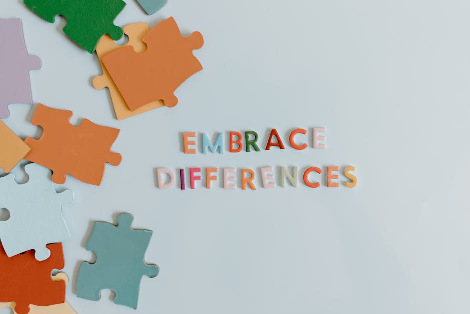 Multicolored jigsaw puzzle pieces with 'Embrace Differences' text on white background.